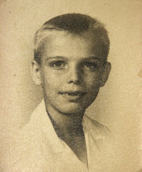 A sepia school portrait of Bob McNeil as a fair-haired boy in a white collared shirt