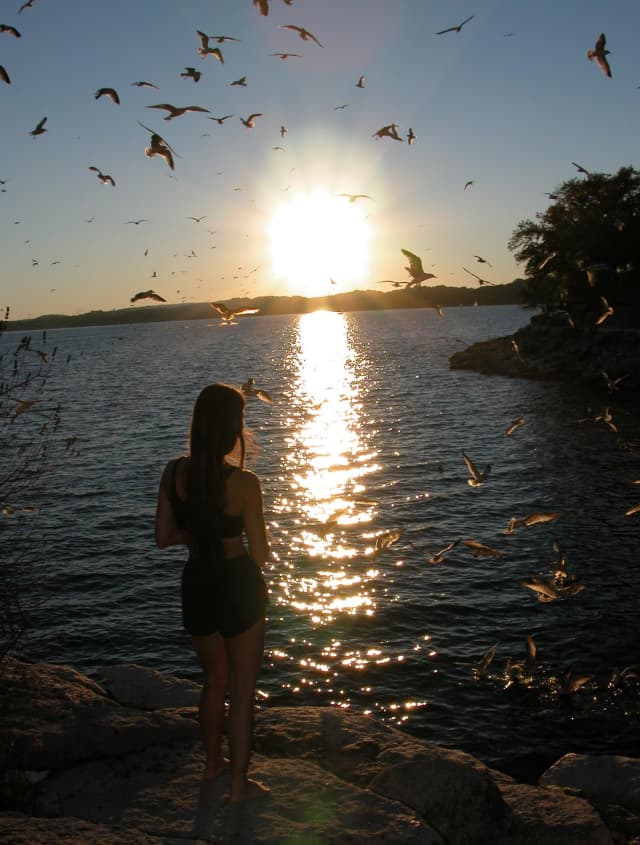 Lake Travis Texas - Girl Feeding Birds, a portrait photograph by Bob McNeil